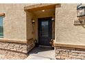 Close-up view of front door with sidelight windows, dark color, and decorative sconces at 8046 W Agora Ln, Phoenix, AZ 85043