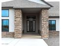 View of the front entrance shows custom stone pillars, a hanging light fixture and a double door entry at 34949 N Donald Way, San Tan Valley, AZ 85140
