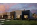 Modern home with a well-manicured lawn and inviting exterior lighting, creating a warm and welcoming ambiance at 5439 E Bloomfield Rd, Scottsdale, AZ 85254