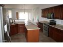 Features an island, stainless appliances, and dark wood cabinetry at 2123 W Maldonado Rd, Phoenix, AZ 85041