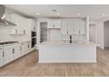 Bright, modern kitchen featuring white cabinets, subway tile backsplash, stainless steel appliances, and a large central island at 23724 N 165Th Dr, Surprise, AZ 85387