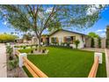 Charming home with lush, green landscaping, rustic shutters, and a wood and post fence along the front of the yard at 4316 N 86Th Pl, Scottsdale, AZ 85251