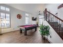 Bright game room features a pool table, staircase with wrought iron railing, and lots of natural light at 8246 W Melinda Ln, Peoria, AZ 85382