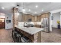 Charming kitchen with brick accents on the island, stainless steel appliances, and granite countertops at 8246 W Melinda Ln, Peoria, AZ 85382