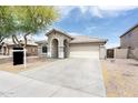 Well-maintained single-story home featuring a spacious driveway and desert landscaping at 4352 W St Catherine Ave, Laveen, AZ 85339