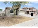 Inviting single-story home with a well-manicured front yard and attached two-car garage at 4352 W St Catherine Ave, Laveen, AZ 85339