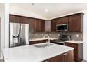 Modern kitchen featuring stainless steel appliances, quartz countertops, and dark wood cabinets at 4352 W St Catherine Ave, Laveen, AZ 85339