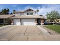 Charming two-story home featuring a three-car garage and desert landscaping with a tile roof at 502 W Sierra Madre Ave, Gilbert, AZ 85233