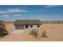 Single-story home with a brown tile roof, complemented by desert landscaping and a wide driveway at 6023 N Nigal Rd, Casa Grande, AZ 85122