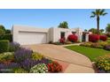 Charming home featuring a pristine white facade and colorful landscaping at 740 W Mountain View Dr, Mesa, AZ 85201