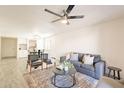 Bright living room with contemporary ceiling fan, stylish furniture, and a view into the dining area at 10828 N Biltmore Dr # 113, Phoenix, AZ 85029