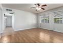 Spacious living room featuring hardwood floors, abundant natural light, and a ceiling fan at 13148 N 21St Ave, Phoenix, AZ 85029