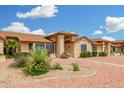 Charming single-story home showcasing beautiful landscaping with vibrant bushes and desert plants at 13630 W Aleppo Dr, Sun City West, AZ 85375