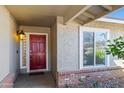 Charming entryway featuring a brick accent wall and a stylish red front door with a decorative glass panel at 15430 N 51St Pl, Scottsdale, AZ 85254