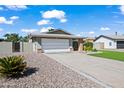 Single story home with a two-car garage, desert landscaping, and a covered entryway at 15430 N 51St Pl, Scottsdale, AZ 85254
