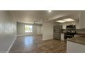Open-concept kitchen featuring stainless steel appliances and sleek countertops and wood flooring at 1615 W Michelle Dr, Phoenix, AZ 85023