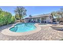 Inviting backyard pool with a spa and a charming stone fire pit surrounded by a brick patio at 1853 W Estrella Dr, Chandler, AZ 85224
