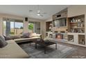 Comfortable living room featuring a stylish fireplace, large sectional sofa, and bright lighting at 18611 E Raven Dr, Queen Creek, AZ 85142