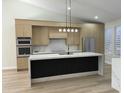 Modern kitchen with island, breakfast bar, stainless appliances, marble counters and backsplash, plus modern cabinets at 20822 N 42Nd. Ave, Glendale, AZ 85308