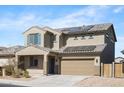 Two-story home showcasing a tile roof, two-car garage, solar panels, and low-maintenance desert landscaping at 21572 W Sonora St, Buckeye, AZ 85326