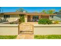 Inviting home exterior with a decorative metal gate, cozy seating area, and well-maintained landscaping at 2246 E Glenrosa Ave, Phoenix, AZ 85016