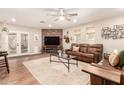 Cozy living room featuring a brick fireplace, plush leather seating, and a ceiling fan for added comfort at 2246 E Glenrosa Ave, Phoenix, AZ 85016