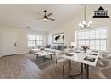 Staged living room featuring vaulted ceilings, modern decor, stylish ceiling fan, and bright windows at 2311 N Loma Vis, Mesa, AZ 85213