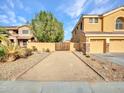 A long, gravel driveway leads to a gated area beside a well-maintained home with mature landscaping at 25453 N 68Th Ln, Peoria, AZ 85383