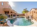 A private pool with rock features and a waterfall is surrounded by desert landscaping in the backyard at 3206 W Sentinel Rock Rd, Phoenix, AZ 85086