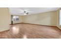 Spacious living room features wood flooring and a ceiling fan at 3220 W Laurie Ln, Phoenix, AZ 85051