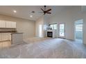 Spacious living room featuring neutral carpet, a fireplace, and a ceiling fan at 3310 E Fremont Rd, Phoenix, AZ 85042