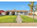 Inviting single-story home features a lush green lawn with a sidewalk, providing a welcoming entrance at 3718 W Columbine Dr, Phoenix, AZ 85029