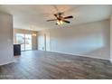 Open-concept living room with tile flooring, ceiling fan, and sliding glass doors to the backyard at 3718 W Columbine Dr, Phoenix, AZ 85029