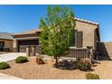 Attractive home featuring a two-car garage, tidy desert landscaping, and a cozy entrance at 41290 W Ganley Way, Maricopa, AZ 85138
