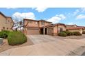 Charming two-story home with a two-car garage, complemented by manicured shrubs and blue skies at 6818 W St Catherine Ave, Laveen, AZ 85339