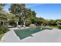 Luxurious pool area featuring lounge seating and waterfall feature at 7250 E Paradise Dr, Scottsdale, AZ 85260