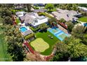 View of a private tennis court, putting green, and swimming pool in the landscaped backyard of a luxury Scottsdale home at 87 Biltmore Est, Phoenix, AZ 85016