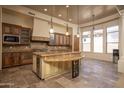 Open kitchen with custom cabinetry, large island, stainless steel appliances, and travertine flooring at 8925 E Ann Way, Scottsdale, AZ 85260