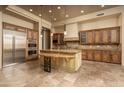 Open kitchen with custom cabinetry, large island, stainless steel appliances, and travertine flooring at 8925 E Ann Way, Scottsdale, AZ 85260