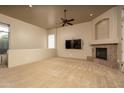 Spacious living room with cozy fireplace, a ceiling fan, neutral carpet and abundant natural light at 8925 E Ann Way, Scottsdale, AZ 85260