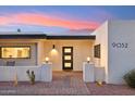 Inviting front entrance with a modern door, white stucco, desert landscaping, and a beautifully colored sky at 9052 N 29Th St, Phoenix, AZ 85028
