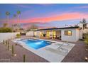 An inviting backyard boasts a sparkling pool, desert landscaping, and an outdoor seating area perfect for relaxation at 9052 N 29Th St, Phoenix, AZ 85028