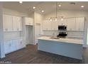 Contemporary kitchen with stainless steel appliances, white cabinetry, and an expansive central island at 9430 W Sandstone Mountain Dr, Casa Grande, AZ 85194