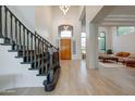 Grand entryway featuring high ceilings, hardwood floors, and a staircase with black banister at 10843 E Acacia Dr, Scottsdale, AZ 85255