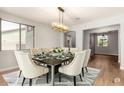 Bright dining room featuring a stylish chandelier, seating for eight, and views of the adjacent room at 12048 N 146Th Ave, Surprise, AZ 85379