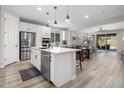 Open-concept kitchen with stainless steel appliances and island seating, seamlessly connecting to living spaces at 32538 N 133Rd Ave, Peoria, AZ 85383