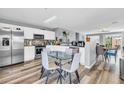 Eat-in kitchen showcases stainless appliances, white cabinetry, mosaic backsplash, and a breakfast nook with a glass table at 8972 E Arizona Park Pl, Scottsdale, AZ 85260
