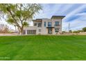 Contemporary home boasts a well-manicured lawn, sleek design, expansive windows, and a dark-colored trim at 100 W Northern Ave # 15, Phoenix, AZ 85021