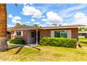 Charming brick home with manicured lawn and desert landscaping under a sunny sky at 10418 W Corte Del Sol Oeste --, Sun City, AZ 85351
