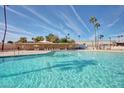 Large community swimming pool with lounge chairs, shade, and palm trees at 10461 W Hutton Dr, Sun City, AZ 85351